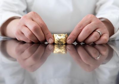 Midsection of woman holding chocolate over table