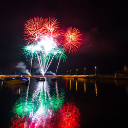 Firework display over river at night