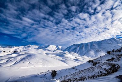 Scenic view of snowcapped mountains against blue sky