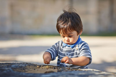 Arabian child fun on the street with small rocks in a puddle