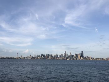Sea by buildings against sky in city