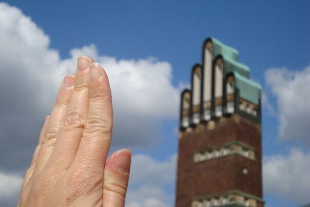 LOW ANGLE VIEW OF CROPPED HAND AGAINST THE SKY