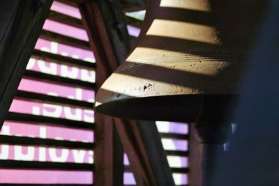 Low angle view of electric lamp hanging on staircase