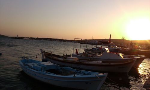 Boats in sea at sunset