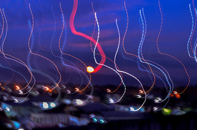 Low angle view of illuminated lights against sky at night