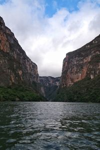 Scenic view of river and mountains against sky