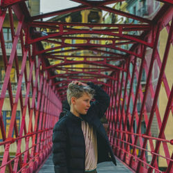 Man standing on bridge in city