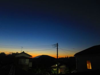 Silhouette buildings against clear sky at sunset