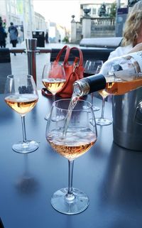 Close-up pouring wine out of a bottle into wine glass on a table