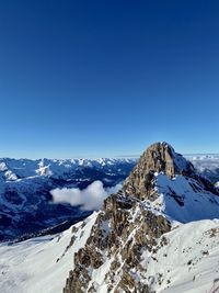 Scenic view of snowcapped mountains against clear blue sky