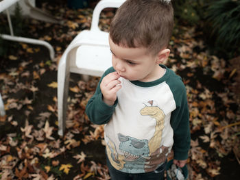 Young boy playing in the backyard on a warm day in late autumn