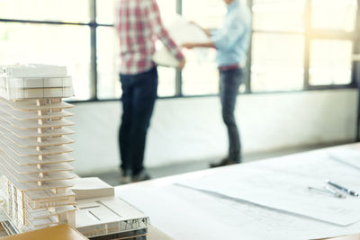 Stack of man standing on table by window