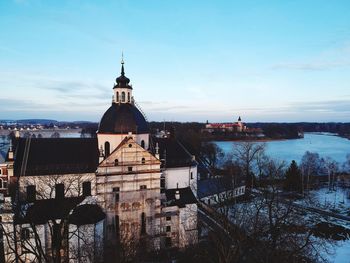 Church by building against sky during winter