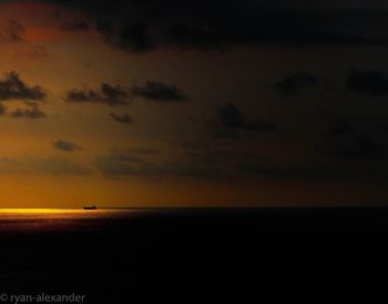 Scenic view of sea against dramatic sky during sunset