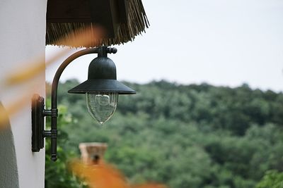 Electric lamp hanging against sky