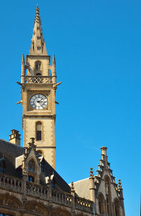 Low angle view of clock tower against clear blue sky