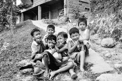 Portrait of happy friends sitting on grass