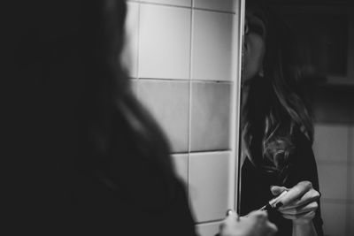 Portrait of woman holding camera at home