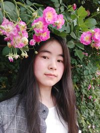 Portrait of young woman with pink flowers