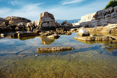 Scenic view of rock formation in lake against sky