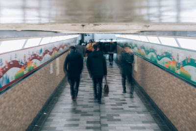 Rear view of people walking in subway