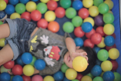 Cropped image of person holding colorful balloons