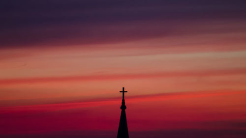 Cross on top of church against sky during sunset