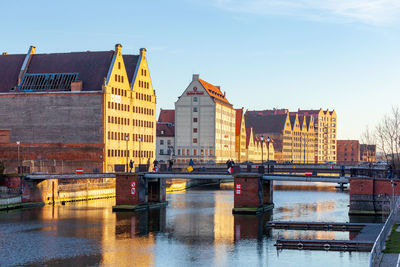 Bridge over river in city against sky