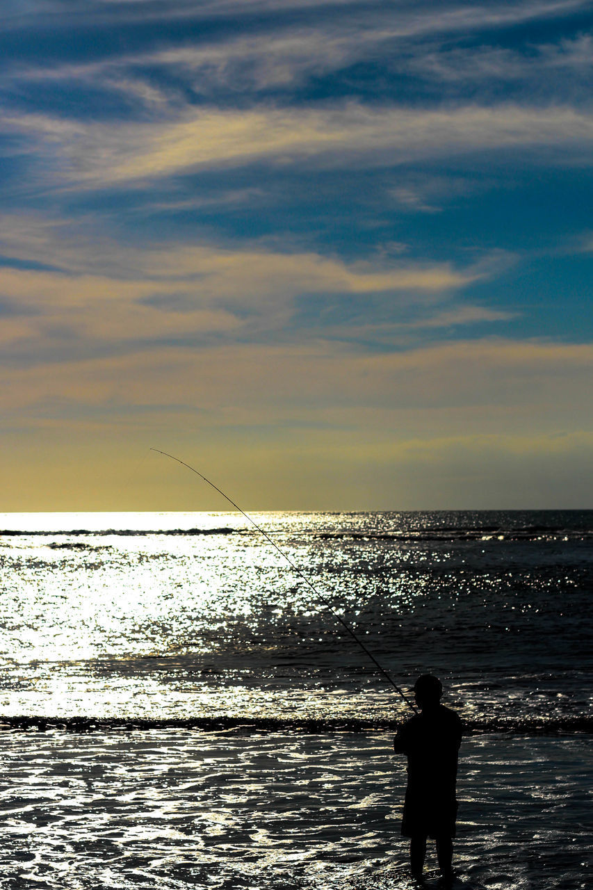 SILHOUETTE MAN FISHING ON SEA AGAINST SKY