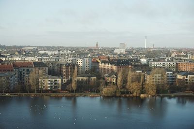 River by cityscape against sky