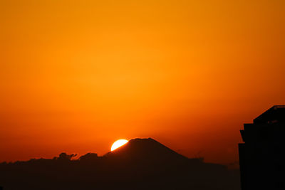 Scenic view of silhouette mountains against romantic sky at sunset