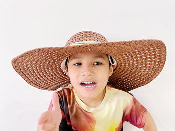 Portrait of boys wearing hat against white background