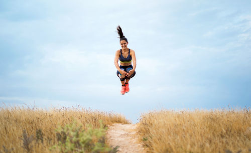 Full length of man jumping on land against sky