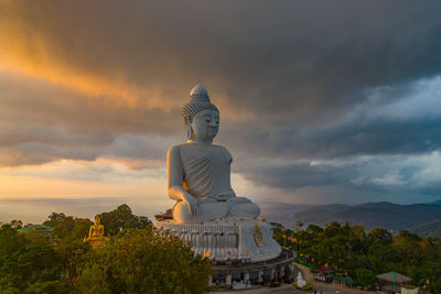 Statue against building and sky during sunset