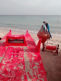 Deck chairs on beach against sky