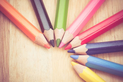 Directly above shot of colored pencils on wooden table