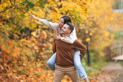 Young woman standing with autumn leaves