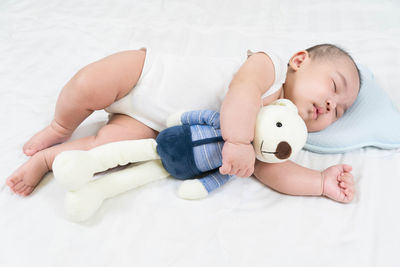 High angle view of baby lying on bed