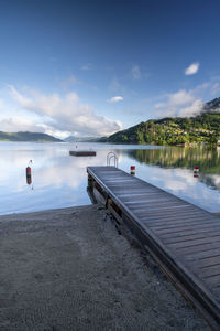 Scenic view of lake and jetty against sky