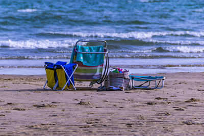 Chairs on beach against sea