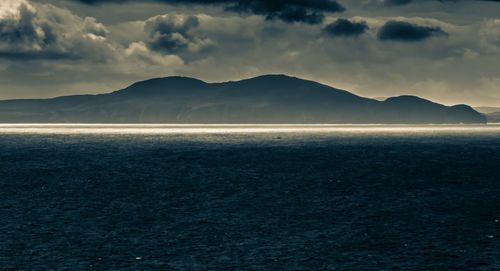 Scenic view of sea and mountains against sky