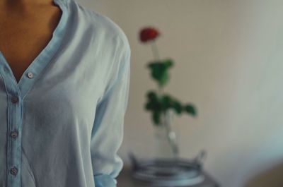 Midsection of woman against wall at home