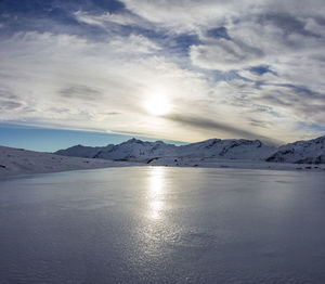 Scenic view of frozen lake against sky during sunset