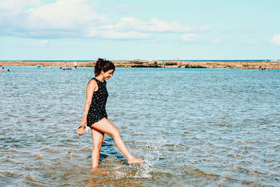 Full length of man standing on beach against sky