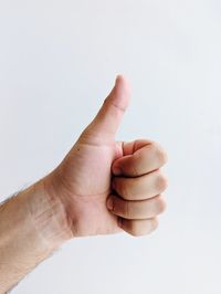 Cropped hand of person gesturing against white background