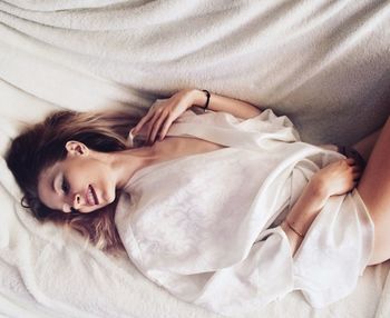 High angle view of woman lying on bed