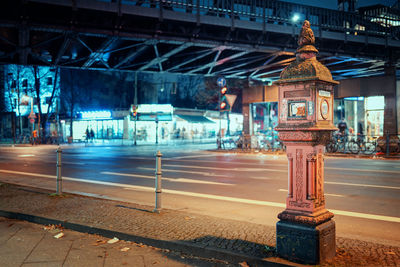 Statue on illuminated street at night