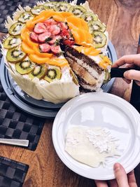 Cropped image of hand cutting cake