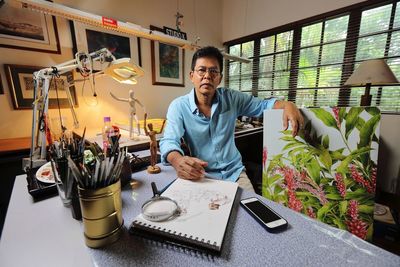 Young man using smart phone while sitting on table