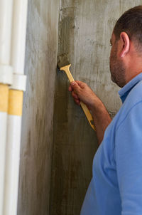 Man working on wood against wall